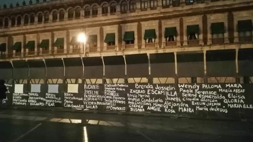 8M: Mujeres escriben nombres de víctimas de feminicidio sobre vallas de Palacio Nacional